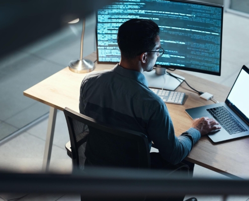 Tech professional looking at code on a computer