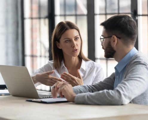 Two business people talking with laptop